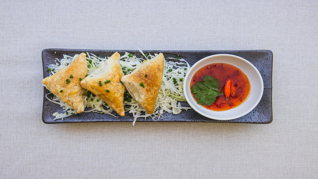 Crispy samosas served with dipping sauce
